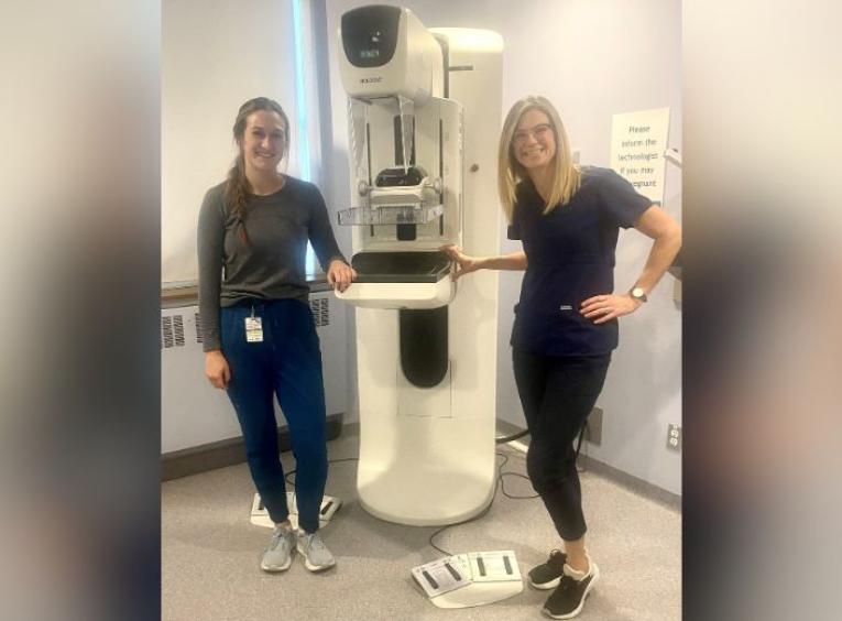Meagan Warner and Rebecca White, mammography technologists, posing with mammogram  equipment
