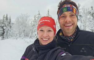 Man and woman wearing winter headbands in a snowy landscape