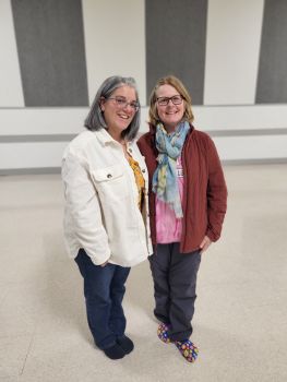 Two women smile posing for the camera
