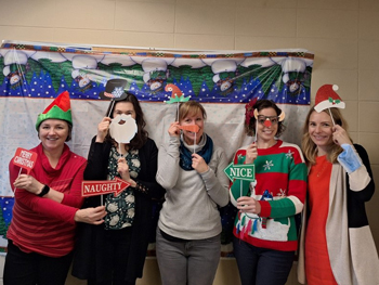 Group of five dietitians use Christmas themed props to pose for a photo. 