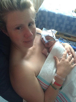 Woman holds newborn baby skin-to-skin
