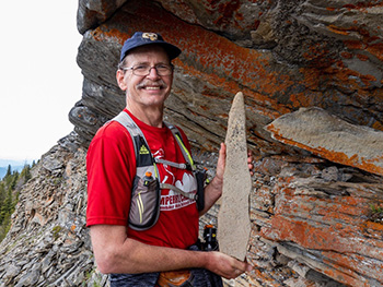 Man in running gear holds large fossil