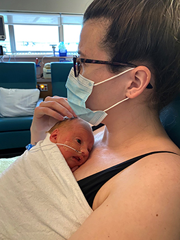 Newborn with feeding tube lays skin to skin with mom