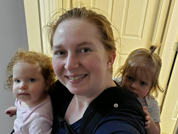 Woman smiling holding twin baby girls