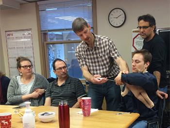 A man demonstrates for a group of health care staff 