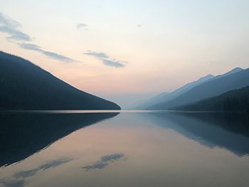 Beautiful mountains surrounding calm lake.