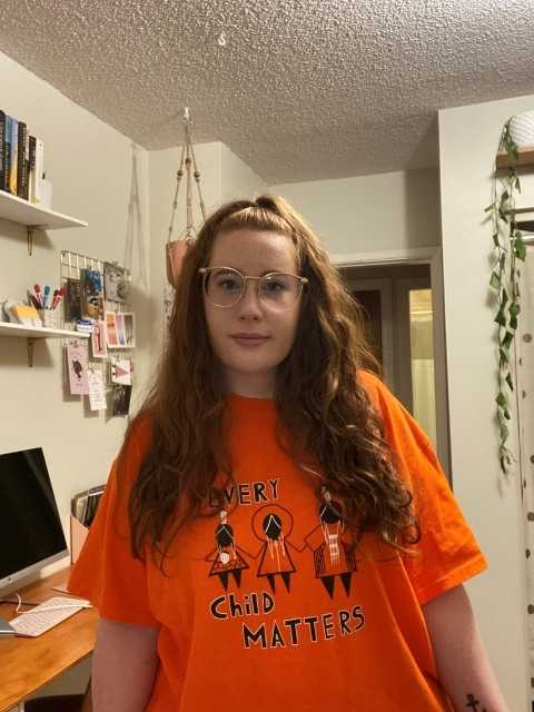 picture of a woman with red hair wearing an orange shirt day shirt