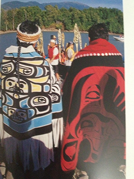 Two Indigenous brothers stand in ceremonial dress.