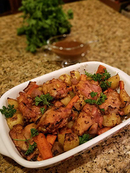 Casserole dish sits on a counter with a Portuguese chicken dish in it