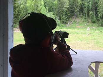 Boy taking aim at shooting range