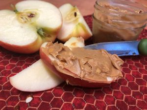 Apple slices with peanut butter on one of them.