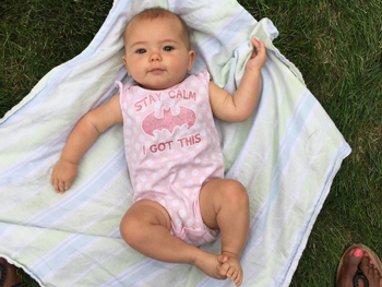 Baby lays on blanket on the grass