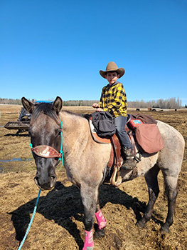 Eight year old Roenick readies his horse Valentine to evacuate