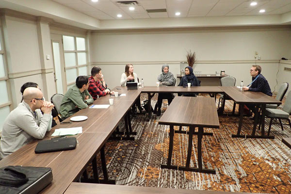 A group of people sitting around a boardroom table.