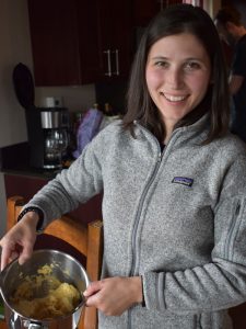 A woman holding a pot of ingredients to make tortillas.