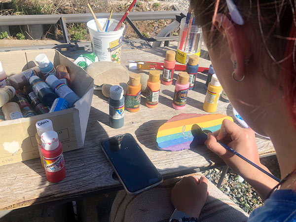 A girl paints a rock.