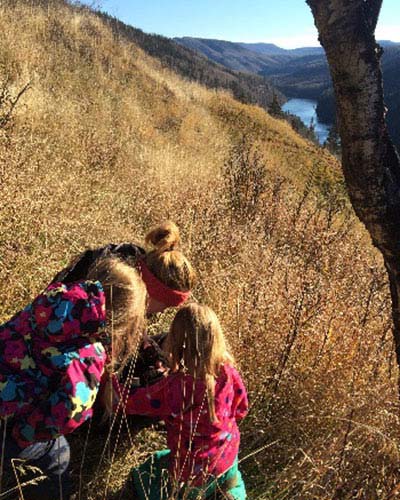 Family geocaching on hillside above a river and valley