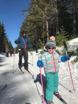 A child and parent skiing