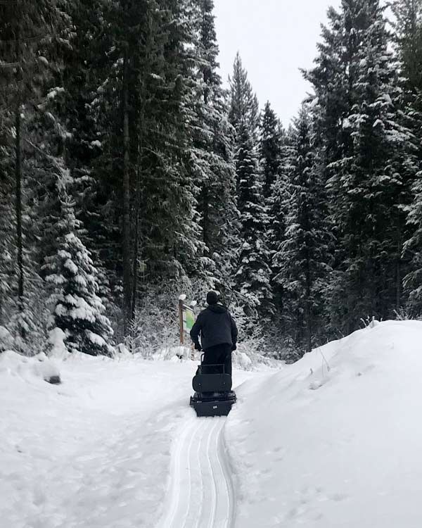 A person rides a trail making machine. 