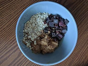 Oats, chocolate, and dried cranberries in a bowl.