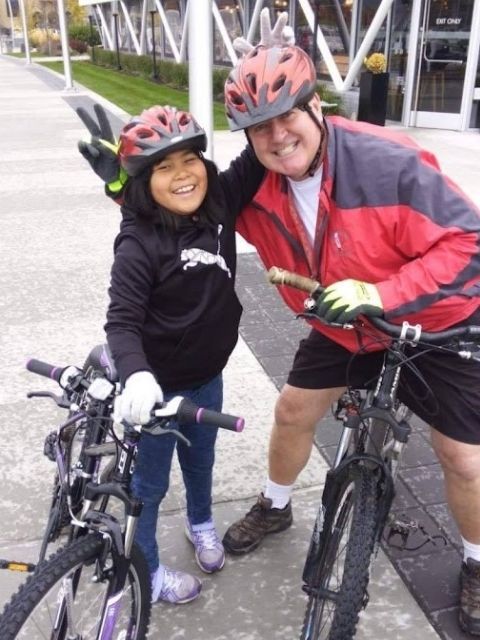 James and a young women standing with bikes and smiling