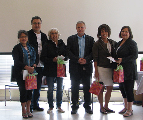 Group of six adults with gift bags.