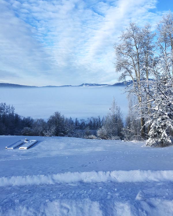 A fog-covered lake with mountains on the horizon.