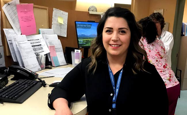 Lyndsey Rhea sits at a desk at G.R. Baker Hospital.