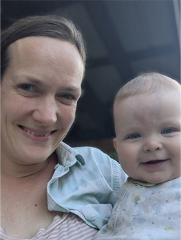 a woman with brown hair holds a cute baby