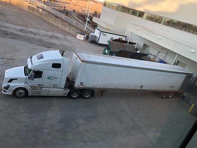 a large shipping truck is park outside a loading area