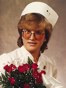 Nurse in graduation photo with cap wearing glasses