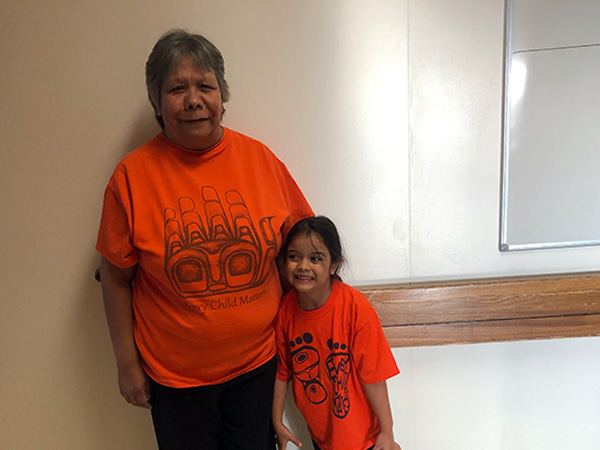 Prince Rupert Hospital staff member and her granddaughter wearing orange shirts