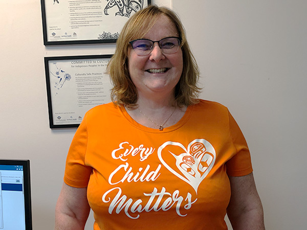 Prince Rupert Hospital staff member posing in her orange shirt