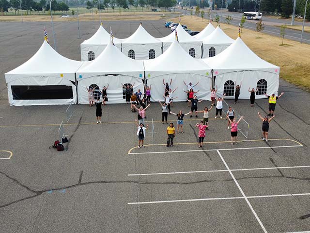 an areal shot of a group of people standing outside of an event tent