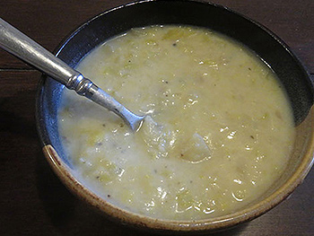 Bowl of cream of potatoe and leek soup with spoon