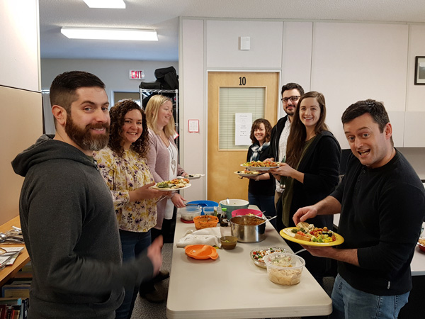 People enjoying a workplace potluck.