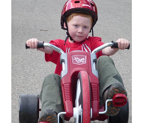 Kid on three wheel slider bike