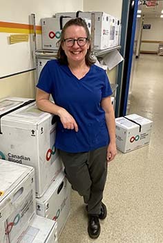 Woman stands beside blood donation boxes