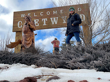 Woman standing next to sign for Chetwynd BC