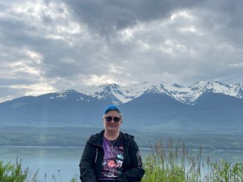 Nicole standing with mountains as a backdrop