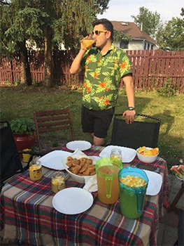 Man enjoying drink with a Hawaiian shirt.