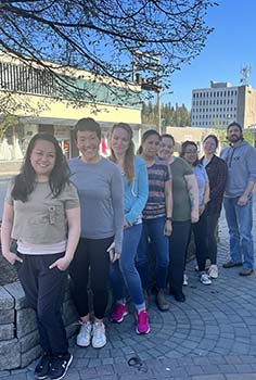 a group of people stand in a line outside 