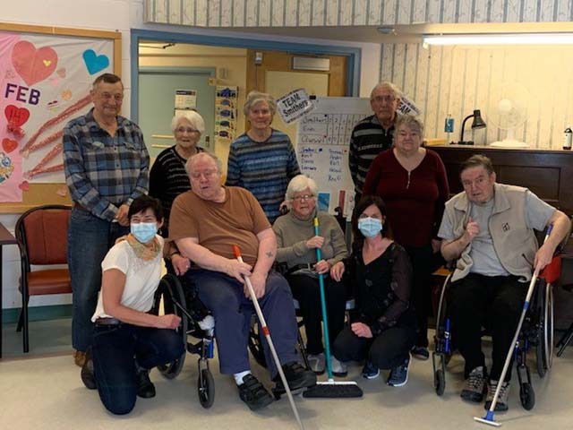 Group of residents and staff pose for picture