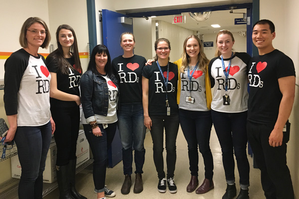 7 women and 1 man wearing tee-shirts with I heart r d s.