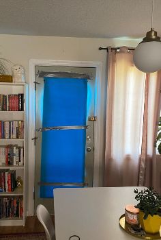 a long window on a door is covered with a yoga mat to block out the sun and heat