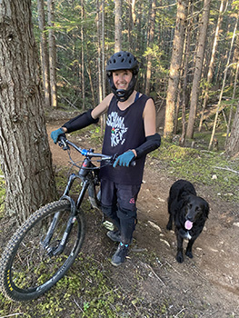 Mountain biker on trail with dog