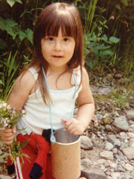 Young girl picking berries and flowers.