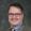 Man with glasses in a suit and tie.