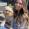 Young woman with long hair holds small white dog