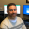 Andrew Steele smiles at camera in his office. 